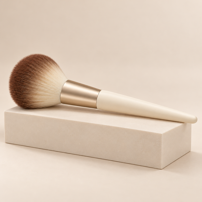 Cloud Dome Powder Brush — three-quarter view on cream pedestal