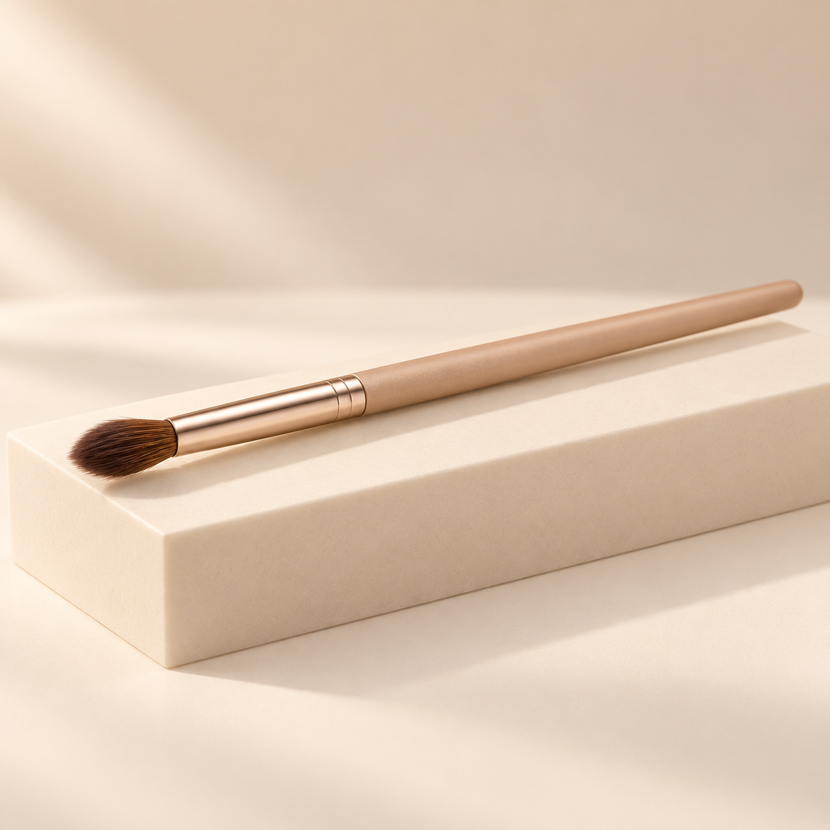 Tapered Crease Brush — three-quarter view on cream pedestal