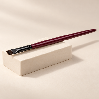 Angled Liner Brush — three-quarter view on cream pedestal