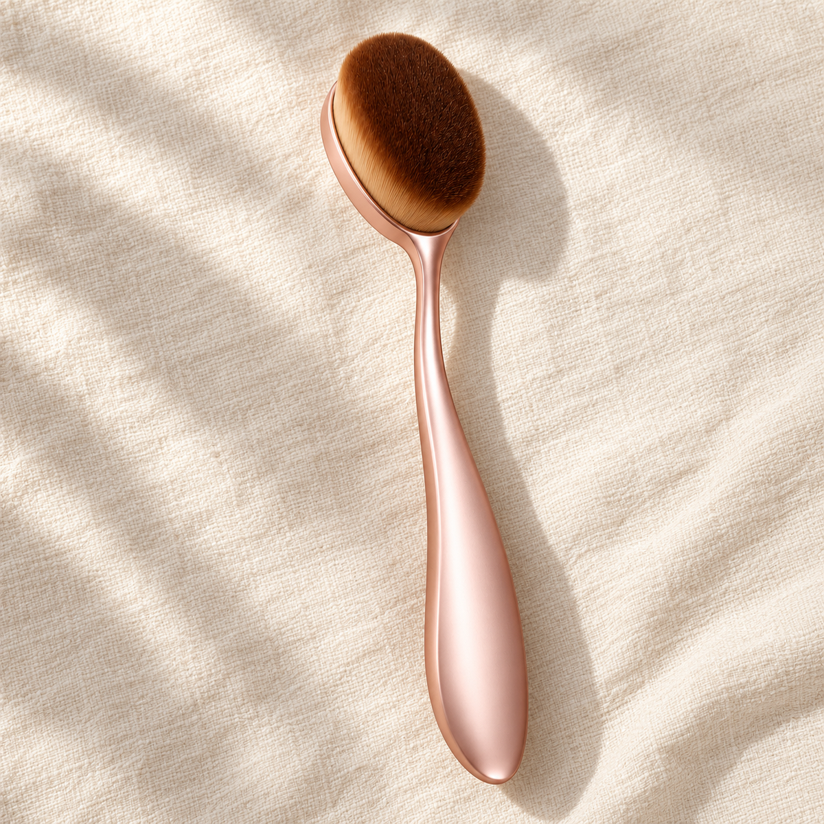 Oval Foundation Brush — overhead view on ivory linen